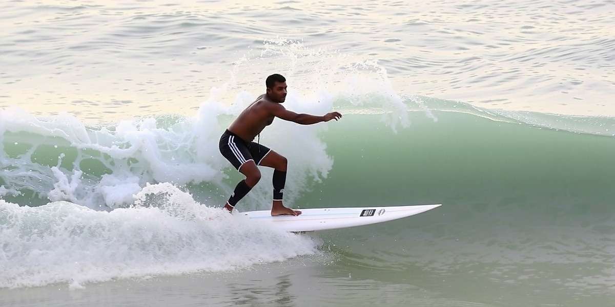 Benaulim Blitz player competing in surfing challenge showing proper technique for riding Indian ocean waves